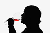 Mann trinkt Rotwein aus einem Weinglas