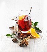 A glass of mulled wine with cinnamon and orange slices