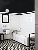 Badezimmer mit schwarzweissem Fliesenboden, Waschbecken und Badewanne vor weissen Wandfliesen, darüber schwarze Wand