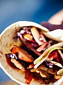 A wrap with grilled sausage, onions and peppers for a winter picnic