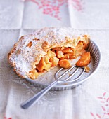 Half and apple pie dusted with icing sugar
