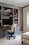 Cream office chair at pale grey shelving with integrated desk and plasma screen