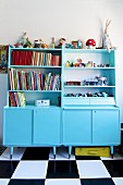 Dressers painted pale blue in child's bedroom with chequered floor