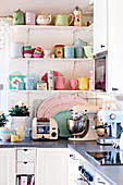 Pastel, retro crockery on shelving above kitchen counter