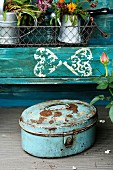 Blue potting table with wire basket and rusty metal tin