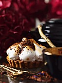 A vanilla tartlet topped with meringue and grated chocolate