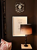 Table lamp with dip-dye-style lampshade in front of pictures on dark brown wall