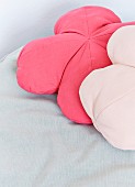Two flower-shaped scatter cushions in shades of pastel pink