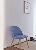 Blauer Fifty Stuhl vor weisser Wand im schlichten weißen Flur