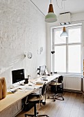 Büro mit langer Arbeitsplatte für zwei Personen und Vintage Schreibtischstühle vor der Wand, in minimalistischem Ambiente mit traditionellem Flair