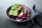 A winter salad with red cabbage, spinach and mango