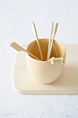 Mini wooden skewers in a wooden cup