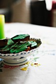 Dish of iced biscuits on embroidered tablecloth