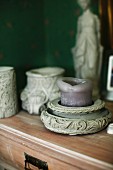 Purple pillar candle in ornate stone candle holder