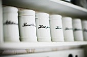 Labelled, white china spice jars on shelf