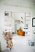 Fabric flowers in vase in antique Greek style in front of lattice partition with view into dining room