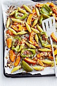 Potato orzo pasta with caramelised pumpkins and peppers on a baking tray