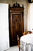 Antique cupboard with carved moulding behind dining set
