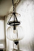 Pendant lamp with spherical glass lampshade hanging from chain