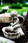 Engelfigur auf Vogelbecken aus Stein im Freien
