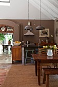 Rustic dining area with old wooden table in open-plan kitchen