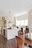 Dining area and island counter in open-plan kitchen with laminate floor