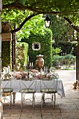 Delicate metal chairs around festively decorated table on terrace