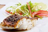 Grilled Cajun-style fish fillet with a salad