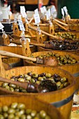 Holzbottiche voll gewürzter Oliven auf einem Markt in London
