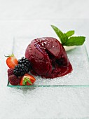 Berry pudding with fresh berries on a glass plate
