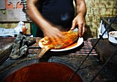Mann beim Zubereiten eines Tandoori-Masala-Fischs