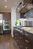 Kitchen with brown cabinets and vent hood; Irvine; California; USA