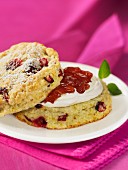 A cranberry scone topped with clotted cream