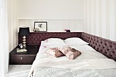 Mit braunen Samtpolstern und Nachtkasten eingerahmtes, französisches Bett in elegantem Schlafraum