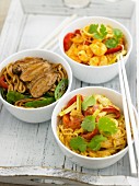 Three Thai noodle dishes; one with duck, one with prawns and one with chicken