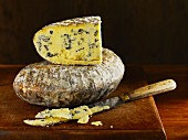 Barkham Blue blue cheese from England with a knife on a wooden board
