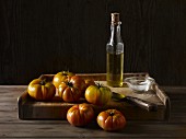 Marmande-Tomaten auf Holzbrett mit Olivenöl, Salz und Messer
