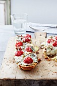 Slices of baguette topped with tomatoes, mozzarella and gorgonzola
