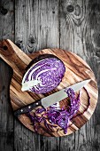 Sliced red cabbage on a chopping board with a knife