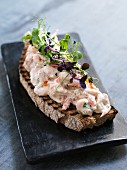 An open sandwich topped with prawn salad