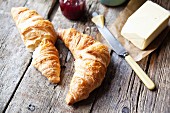 Freshly baked croissants with salted butter and raspberry jam