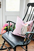 Nostalgic wooden rocking chairs with pink scatter cushion in Nordic country-house interior