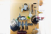 Various kitchen utensils stored on a wall