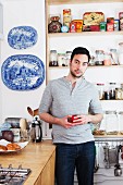Man standing in kitchen holding coffee cup