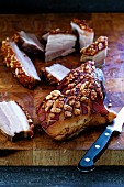 Roast belly pork with crackling on chopping board