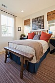 Arranged pillows on bed on rug in bedroom; San Marcos; California; USA