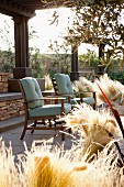 Stühle auf überdachter Terrasse mit dekorativer Grasbepflanzung