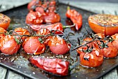 Roasted tomatoes and chillis on a baking tray