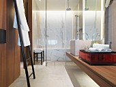Modernes Hotelbadezimmer mit Waschtisch, Handtuchhalter und verglastem Dusch- & Badbereich