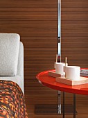 Coffee cups on red table by chaise longue in hotel room